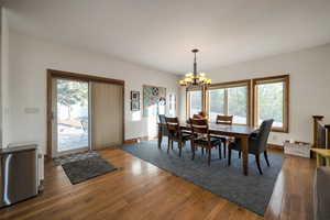 Dining space featuring an inviting chandelier and hardwood / wood-style floors