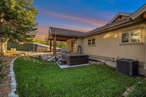 View of yard with a patio, a fenced backyard, a hot tub, and central air condition unit