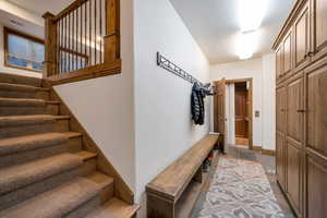 Mudroom featuring storage lockers,  bench, and elevator.