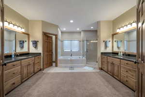 Full bathroom featuring two vanities, separate shower/tub and 2 walk in closets.
