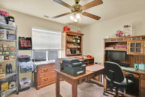 Office area featuring a ceiling fan, light colored carpet, and visible vents