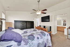 Bedroom with baseboards, ceiling fan, ensuite bath, and light colored carpet