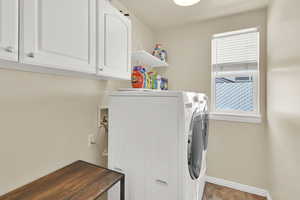 Laundry room featuring baseboards, cabinet space, and washer and clothes dryer
