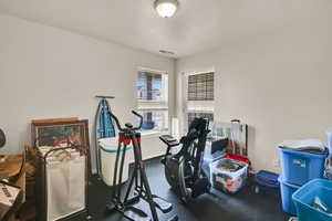 Workout area featuring baseboards and a textured ceiling