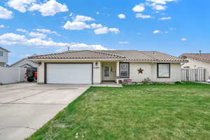 View of front of house with fence, stucco siding, a tiled roof, an attached garage, and driveway