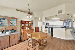 Dining space featuring visible vents, light wood-style floors, and baseboards