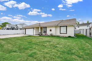 Ranch-style house with fence, a tile roof, a garage, stucco siding, and driveway