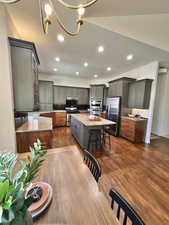 Dining area featuring recessed lighting, baseboards, dark wood finished floors, and a notable chandelier