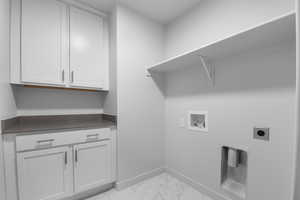Laundry room featuring cabinet space, washer hookup, marble finish floor, baseboards, and hookup for an electric dryer