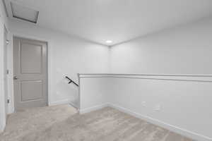 Carpeted spare room featuring baseboards