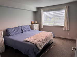 Bedroom featuring carpet and baseboards