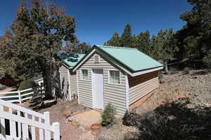 View of outbuilding with fence and an outbuilding