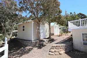 View of side of home with a storage unit and an outdoor structure