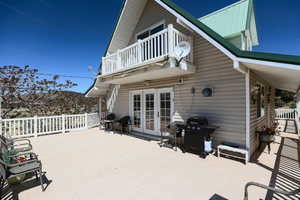 View of patio featuring french doors, a balcony, and a grill