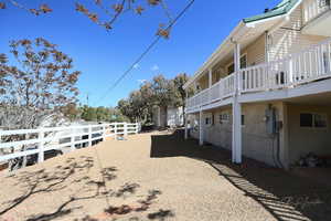 View of yard with fence and a balcony