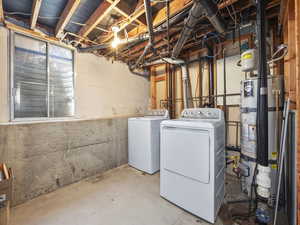Unfinished basement featuring water heater and washer and dryer