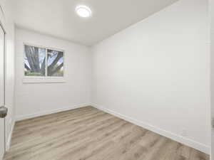 Empty room with baseboards and light wood-type flooring