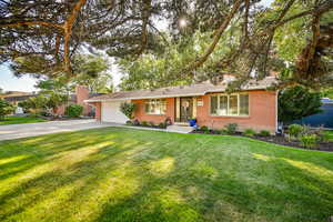 Stunning curb appeal to this red brick home with garage and parking view.