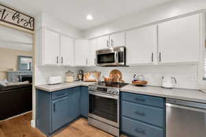 Kitchen space and cabinets with view to living room.