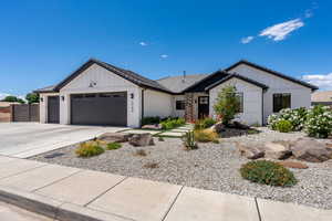View of front of house with board and batten siding, a tile roof, a garage, fence, and concrete driveway