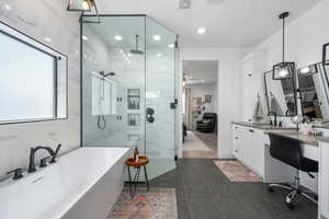 Ensuite bathroom featuring visible vents, vanity, a freestanding tub, connected bathroom, and a marble finish shower