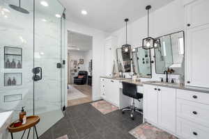 Bathroom with recessed lighting, a marble finish shower, tile patterned flooring, and vanity