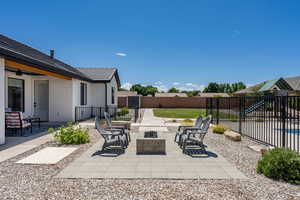 View of patio with a fenced backyard, a ceiling fan, and an outdoor fire pit