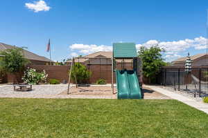 View of jungle gym with a fenced backyard and a yard
