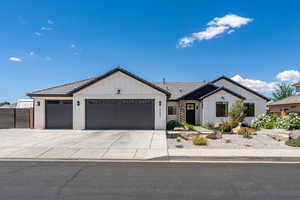Ranch-style house featuring a garage, board and batten siding, driveway, and a tile roof