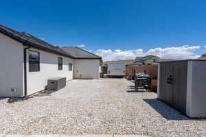 View of yard with a patio, fence, an outbuilding, and a shed