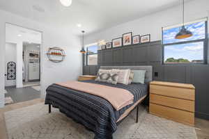 Bedroom featuring recessed lighting, light wood finished floors, and a decorative wall