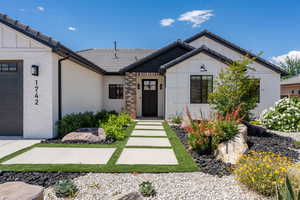 View of front of house with a garage, board and batten siding, and a tile roof