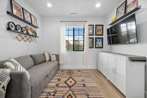 Living area with visible vents, recessed lighting, light wood finished floors, and baseboards