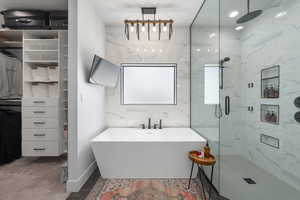 Full bathroom with a freestanding tub and a marble finish shower