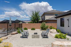View of patio with a fenced backyard and a fire pit