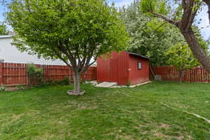 View of yard featuring a fenced backyard, an outbuilding, and a storage shed