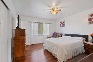 Bedroom with baseboards, ceiling fan, and dark wood-style floors
