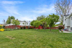 View of yard featuring a fenced backyard, an outdoor structure, a patio, and a storage shed