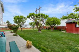 View of yard featuring a patio, a fenced backyard, and an outbuilding