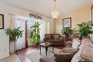 Living room featuring baseboards, a notable chandelier, and vaulted ceiling