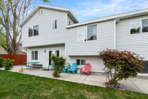 Back of property with a patio area, fence, and a yard