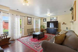 Living area with baseboards, visible vents, and wood finished floors