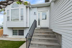 Property entrance featuring fence and brick siding