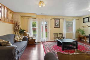 Living room featuring a healthy amount of sunlight, a textured ceiling, and wood finished floors