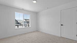 Unfurnished room featuring baseboards, carpet flooring, and visible vents
