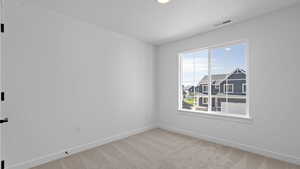 Empty room with visible vents, carpet flooring, and baseboards