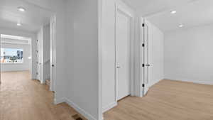 Hall with recessed lighting, baseboards, visible vents, and light wood-style flooring