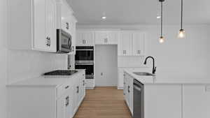 Kitchen featuring a sink, light countertops, backsplash, and stainless steel appliances
