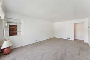 Carpeted spare room with baseboards and visible vents