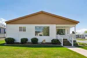 Bungalow featuring a porch and a front lawn